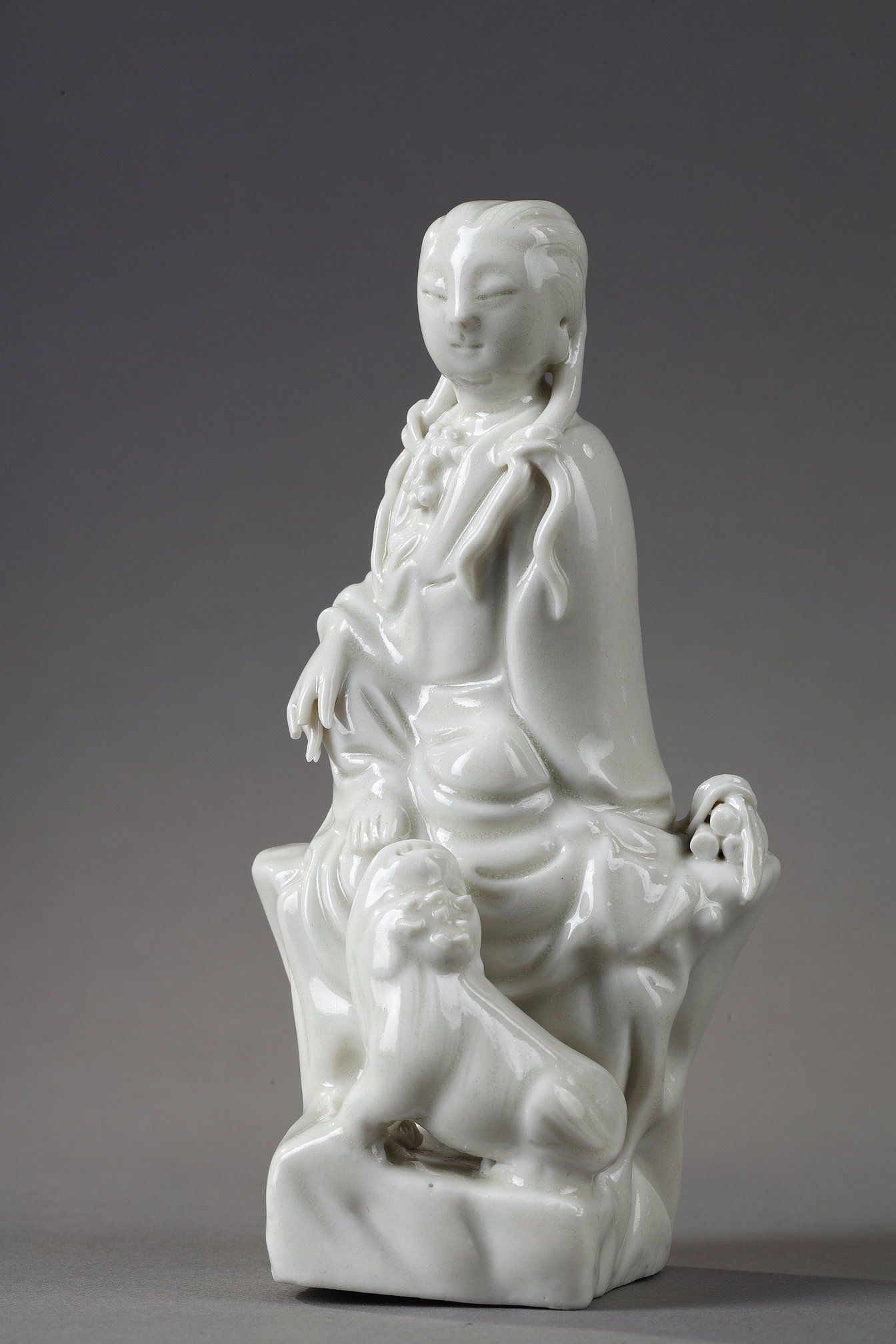 small figure of Guanyin sitting in front of a Fo dog or Buddhist lion made of China blanc de Chine  porcelain kilns of Dehua province of Fujian - China 18/19em 
Mark in the shape of a colocynth on the back